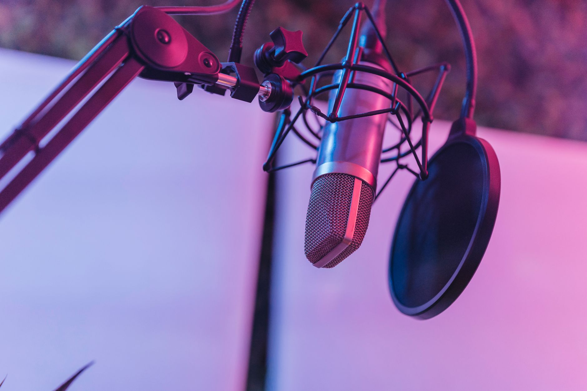 A recording microphone lit in pink and blue